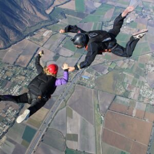 Salto en paracaídas tandem sobre campos y montañas